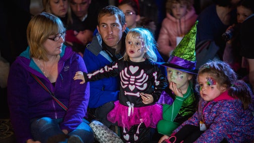 A family watching a Halloween show at Penrhyn Castle and Garden, North Wales